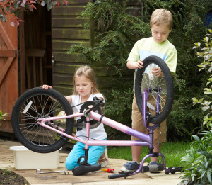 Two Children Cleaning Bike Together